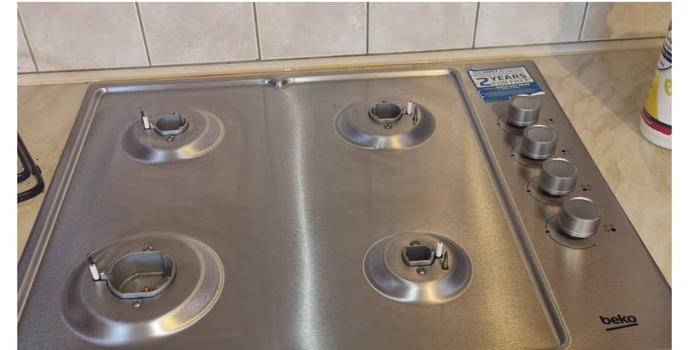 The same gas hob after cleaning, the stainless steel clear and the burners free of residue
